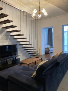 - un salon avec un canapé et un escalier dans l'établissement Dark Apartment, à Erevan
