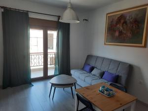 a living room with a couch and a table at Olga's appartments in Ouranoupoli