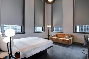 a bedroom with a bed and a couch and windows at Courtyard by Marriott Cincinnati Downtown in Cincinnati