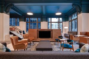 a lobby with a tv and a couch and chairs at Courtyard by Marriott Cincinnati Downtown in Cincinnati