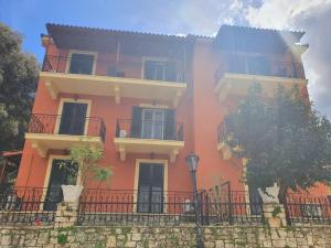 a large orange building with two balconies on it at BELLA DE LUX RESIDENCE in Kato Korakiana
