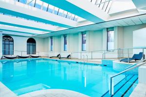 a swimming pool with blue water in a building at Glasgow Marriott Hotel in Glasgow