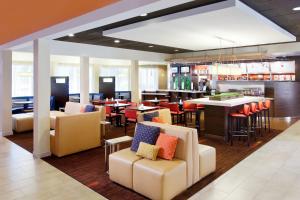 a restaurant with chairs and tables and a bar at Courtyard Sacramento Airport Natomas in Sacramento