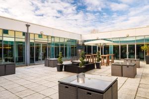 a building with a patio with tables and an umbrella at Delta Hotels by Marriott Nottingham Belfry in Nottingham