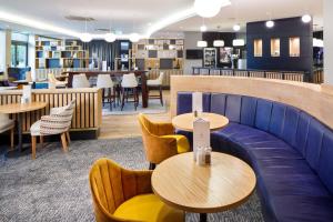ノッティンガムにあるDelta Hotels by Marriott Nottingham Belfryのテーブルと椅子のあるレストラン、バー