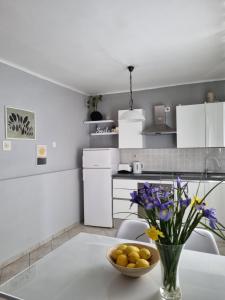 a kitchen with a vase of flowers on a table at Mili Apartament in Vela Luka