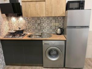 a kitchen with a sink and a washing machine at Cozy Home! in Batumi
