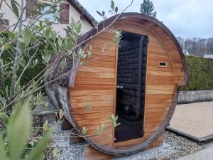 una casa de perros de madera con puerta redonda en LA PORTE DES ALPES en Barberaz