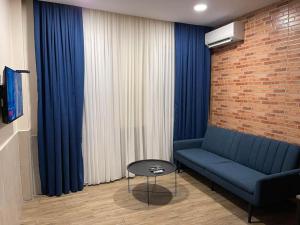 a living room with a blue couch and blue curtains at Cozy Home! in Batumi