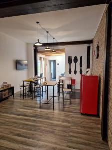 Una habitación con mesas y sillas y un refrigerador rojo. en BB 26 Olbia, en Olbia