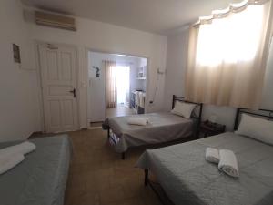 a room with two beds and a door with a window at Mama's House in Ios Chora
