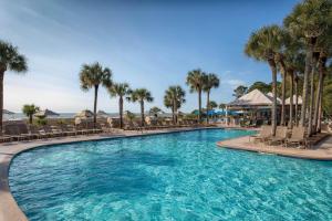 a large swimming pool with chairs and palm trees at Marriott's Grande Ocean in Hilton Head Island
