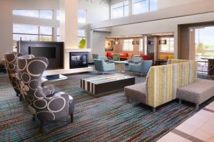 a lobby with chairs and a living room with a tv at Residence Inn by Marriott Houston Pasadena in Pasadena