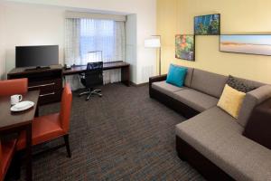 Habitación de hotel con sofá, mesa y escritorio. en Residence Inn by Marriott Fort Lauderdale Airport & Cruise Port en Dania Beach