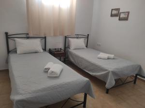 two beds in a room with towels on them at Mama's House in Ios Chora