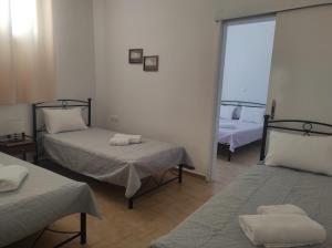 a room with two beds and a window at Mama's House in Ios Chora