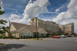 un gran edificio con un coche aparcado en un aparcamiento en Residence Inn Charlotte Concord, en Concord