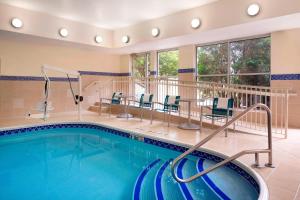 a pool in a hotel room with chairs and a table at TownePlace Suites by Marriott Chicago Naperville in Naperville