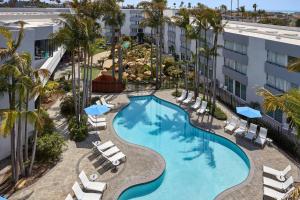 an overhead view of a pool with chairs and palm trees at Ventura Beach Marriott in Ventura