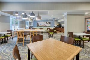 a dining room with tables and chairs and a kitchen at Fairfield Inn & Suites Raleigh Crabtree Valley in Raleigh