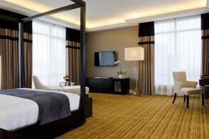 a hotel room with a bed and a flat screen tv at The Majestic Hotel Kuala Lumpur, Autograph Collection in Kuala Lumpur