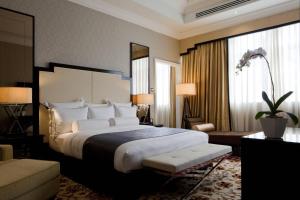 The Majestic Hotel Kuala Lumpur, Autograph Collection في كوالالمبور: غرفة نوم بسرير كبير ونافذة كبيرة