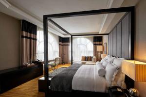 a bedroom with a large bed and a desk at The Majestic Hotel Kuala Lumpur, Autograph Collection in Kuala Lumpur