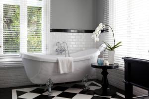 a white bath tub in a bathroom with a window at The Majestic Hotel Kuala Lumpur, Autograph Collection in Kuala Lumpur