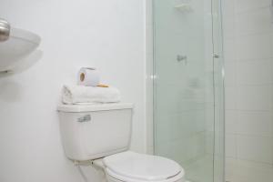 a white bathroom with a toilet and a shower at Ayenda Hotel Muleke in Santa Marta