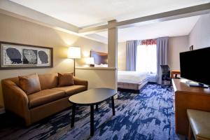 a hotel room with a couch and a bed at Fairfield Inn & Suites by Marriott Atlanta Kennesaw in Kennesaw