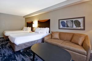 a hotel room with two beds and a couch at Fairfield Inn & Suites by Marriott Atlanta Kennesaw in Kennesaw