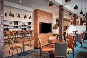 a restaurant with tables and chairs and a tv at Residence Inn by Marriott Wilmington Downtown in Wilmington