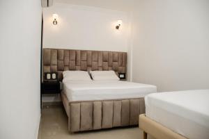 a bedroom with a bed with a tufted headboard at Ayenda Hotel Muleke in Santa Marta