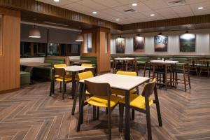a dining room with tables and yellow chairs at Fairfield Inn & Suites by Marriott Canton in Canton