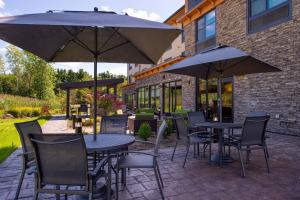 un patio avec des tables, des chaises et des parasols dans l'établissement Fairfield Inn & Suites by Marriott Canton, à Canton