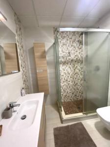 een badkamer met een douche, een wastafel en een toilet bij Torrenueva Lux Seaview Apartment close to Marbella in La Cala de Mijas