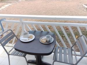 a table with two cups and plates of food on a balcony at Karibbean Sweet Home in Saint-François