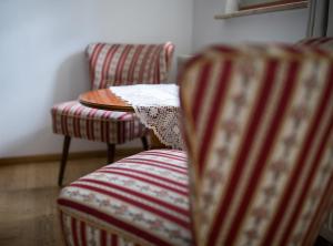 two striped chairs and a table in a room at Jena The Grand Piano Suite in Jena