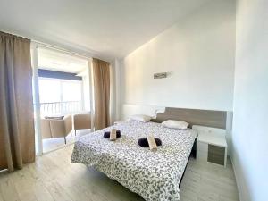 een slaapkamer met een bed met twee schoenen erop bij Torrenueva Lux Seaview Apartment close to Marbella in La Cala de Mijas