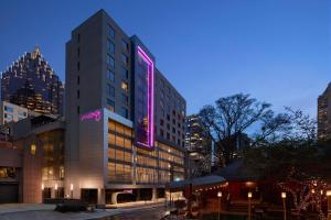 a tall building with a neon sign on it at Moxy Atlanta Midtown in Atlanta