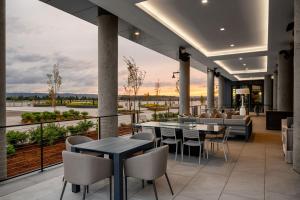a restaurant with tables and chairs on a balcony at AC Hotel by Marriott Vancouver Waterfront in Vancouver