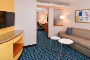 een hotelkamer met een bank en een tafel bij Fairfield Inn & Suites Hattiesburg / University in Hattiesburg