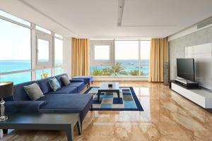 Hurghada Marriott Beach Resort في الغردقة: غرفة معيشة مع أريكة زرقاء وتلفزيون