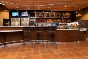 a bar with three bar stools in a restaurant at Courtyard by Marriott Houston City Place in Spring