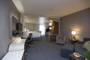 ein Hotelzimmer mit einem Bett und einem Wohnzimmer in der Unterkunft Courtyard by Marriott Houston City Place in Spring