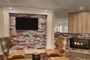 a living room with a fireplace and a flat screen tv at Residence Inn Scranton in Scranton