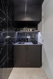 a black kitchen with a sink and a counter at Bounce in Belgrade