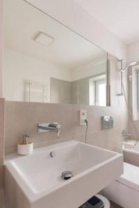 a white bathroom with a sink and a mirror at Modern Home in Central Berlin in Berlin