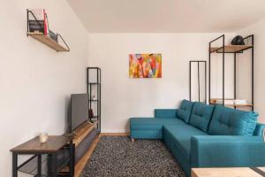 Modern Home in Central Berlin في برلين: غرفة معيشة مع أريكة زرقاء وطاولة