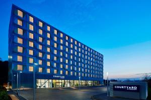 un grand bâtiment avec un panneau devant lui dans l'établissement Courtyard by Marriott Luton Airport, à Luton